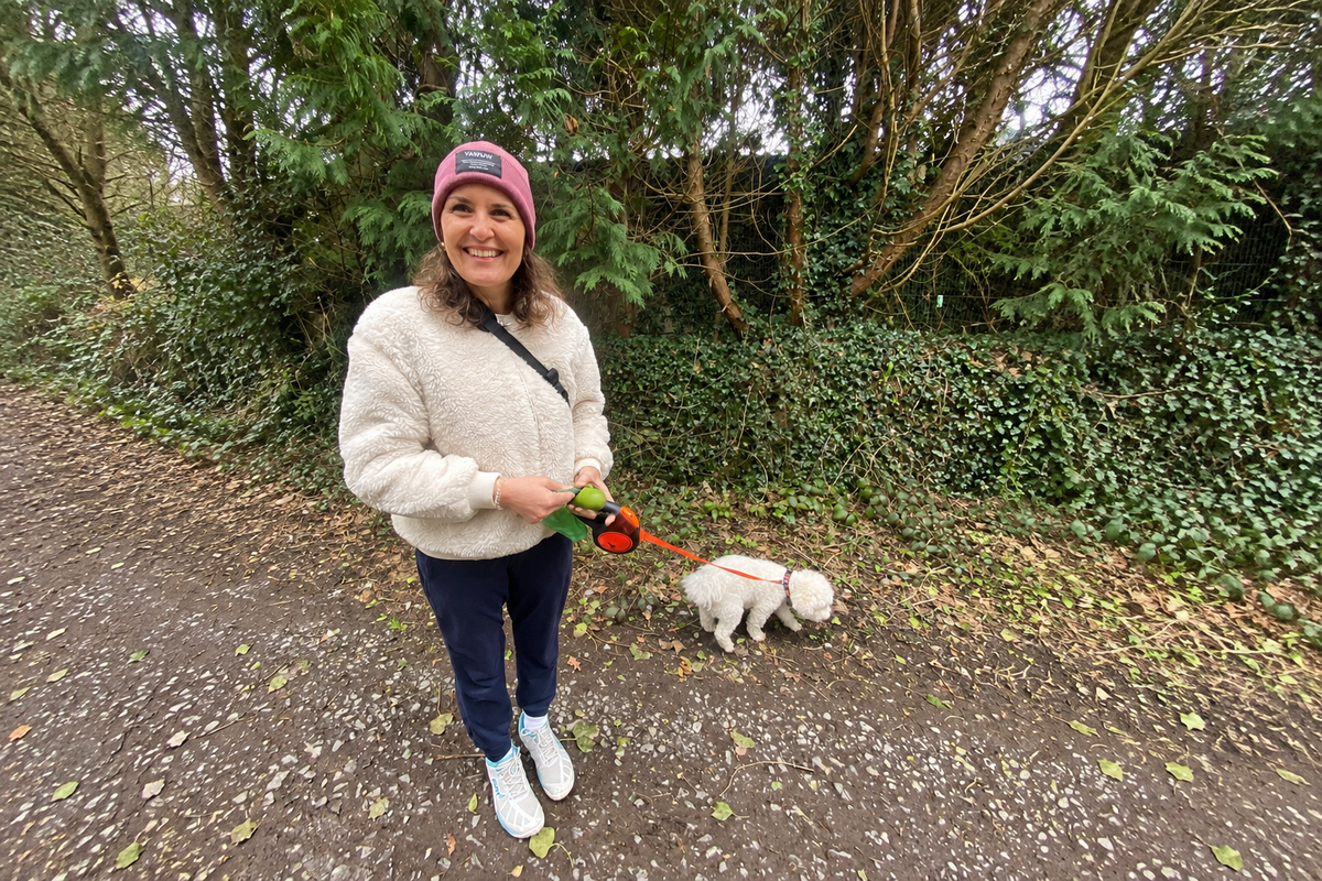 Alex walking one of her dogs in the woods in Cork
